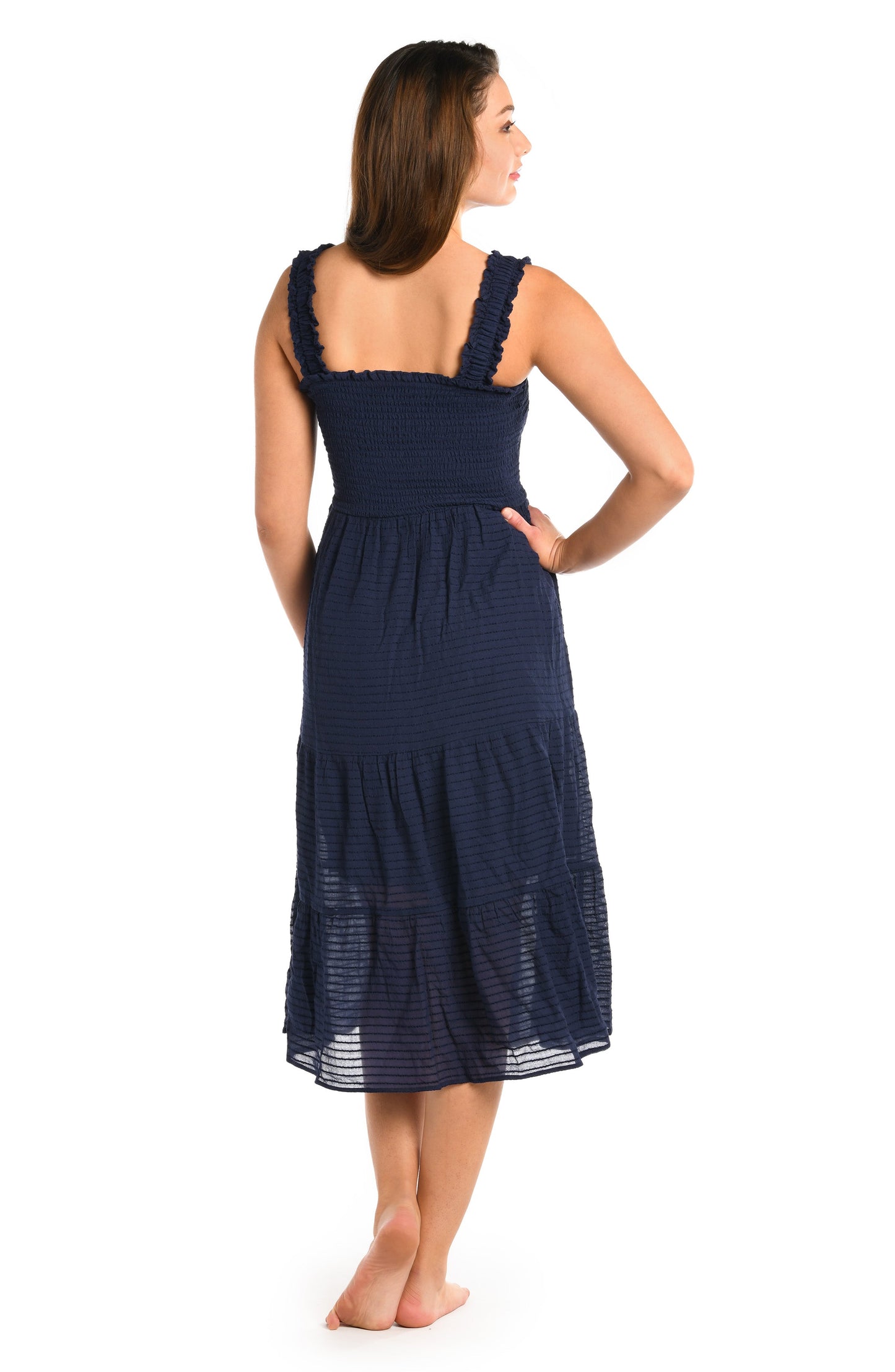 Model is wearing a solid indigo colored smocked tiered midi dress cover up from our Shadow Stripe collection.