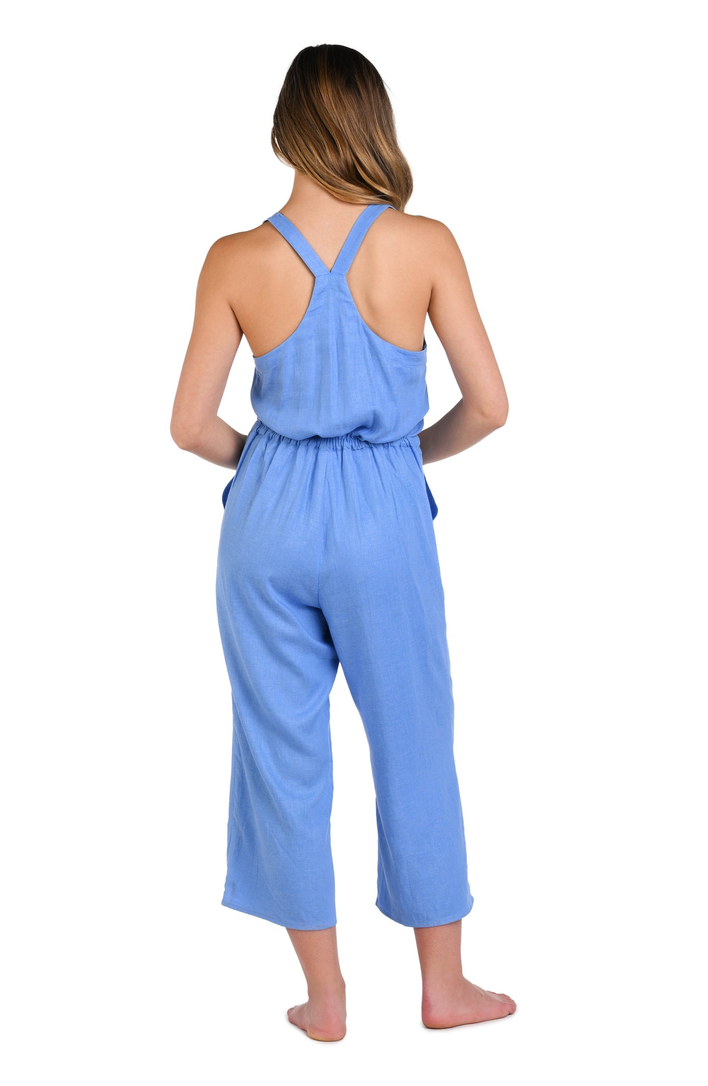 Model is wearing a solid chambray (light blue) colored sleeveless jumpsuit cover up.