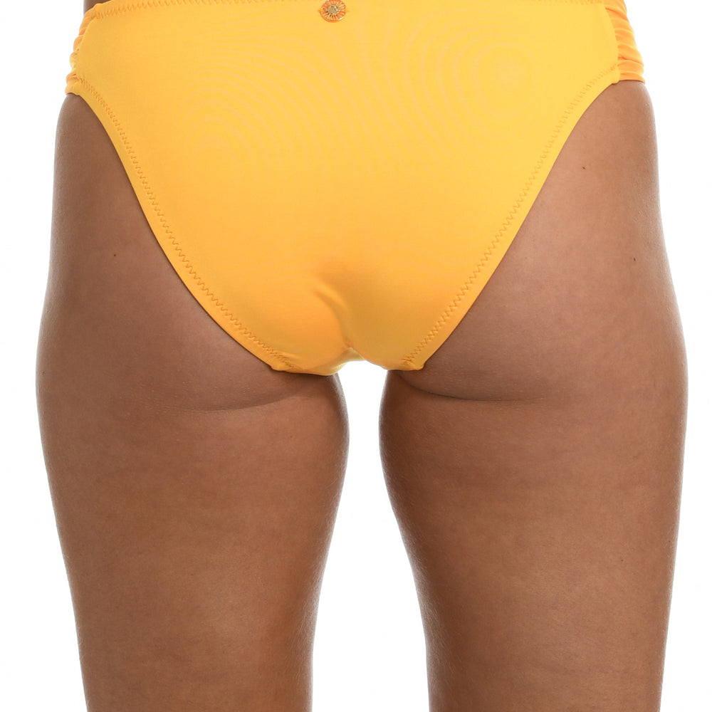 Model is wearing a solid sunshine yellow colored side tie hipster bikini bottom from our Wanderlust Solids collection.