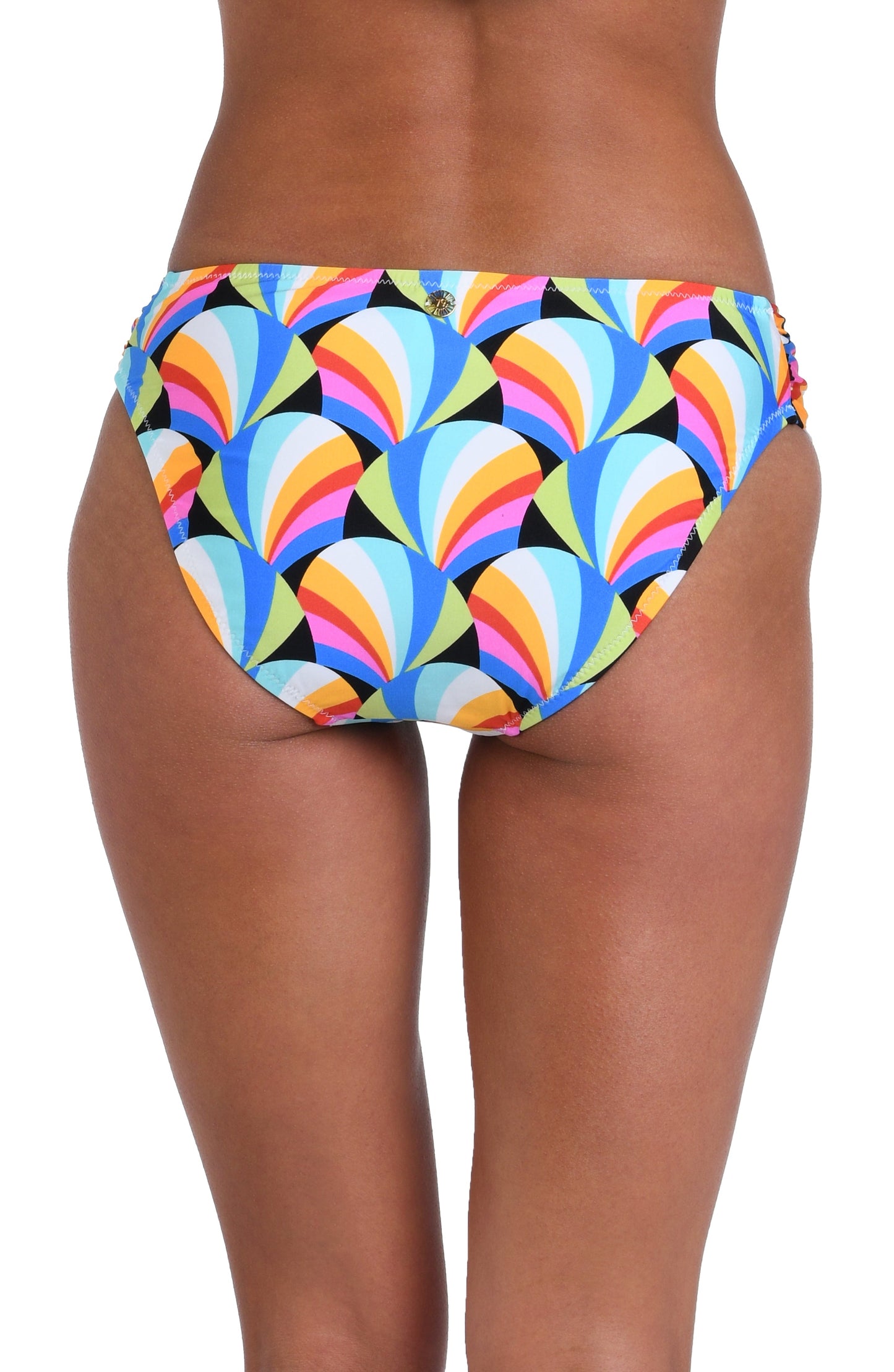 Model is wearing a pink, blue, yellow, and orange multicolored side shirred hipster bikini bottom on a geometric patterned black background.